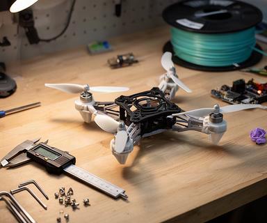 Dron ligero con piezas impresas en 3D sobre una mesa de trabajo maker